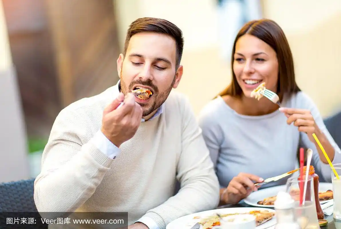 一对情侣在户外吃披萨小吃.