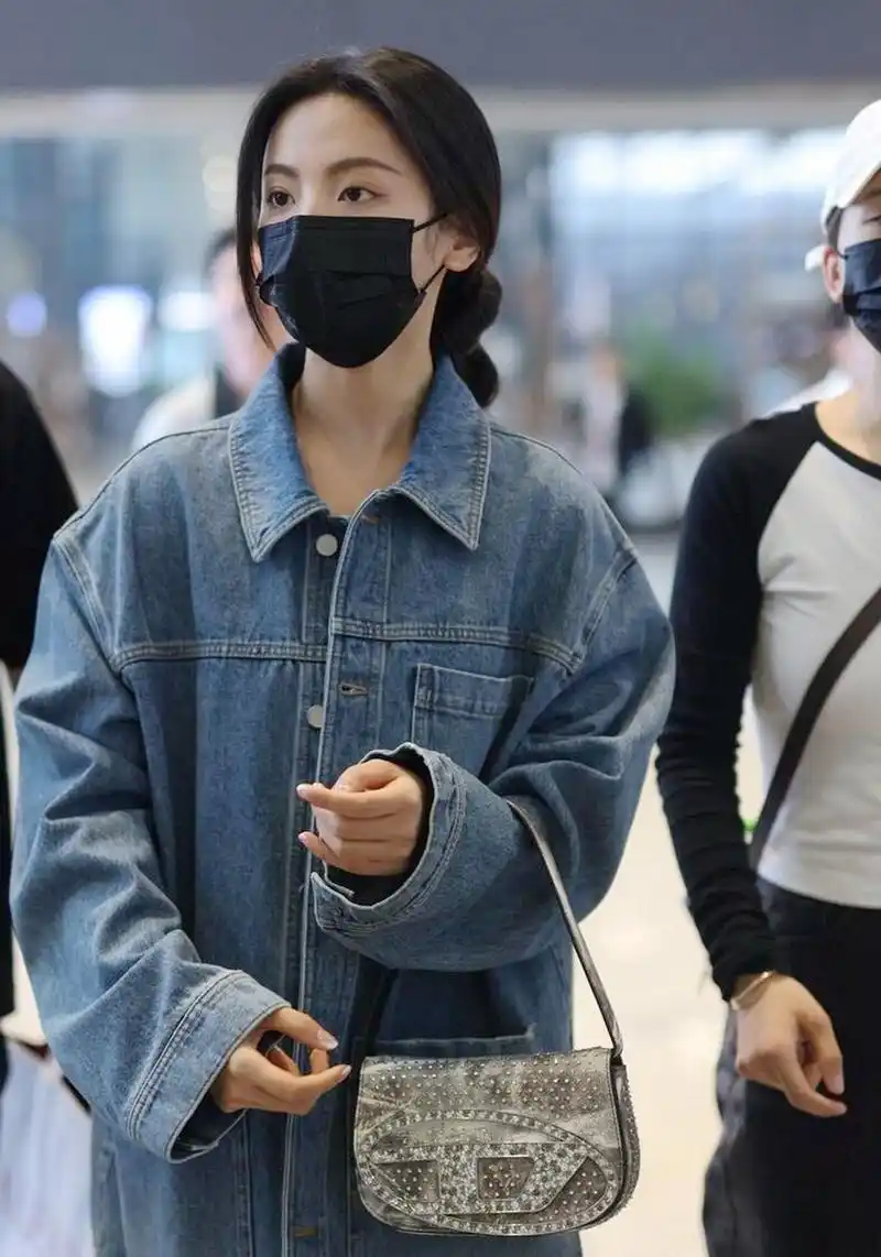 杨超越机场街拍,牛仔外套搭配喇叭裤,背银色包包,舒适又吸睛!