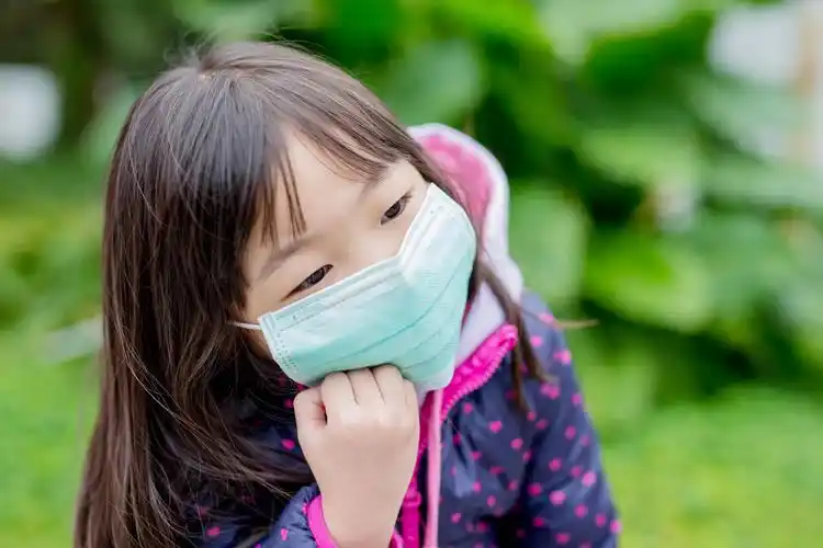 可爱的小女孩得感冒戴口罩