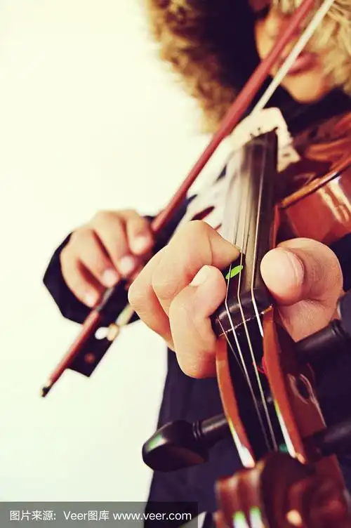 从正面拍摄的垂直镜头,一个男孩在拉着弦乐器,小提琴
