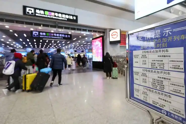 2月17日,铁路部门工作人员(中)在上海虹桥站出站口引导旅客有序出站.