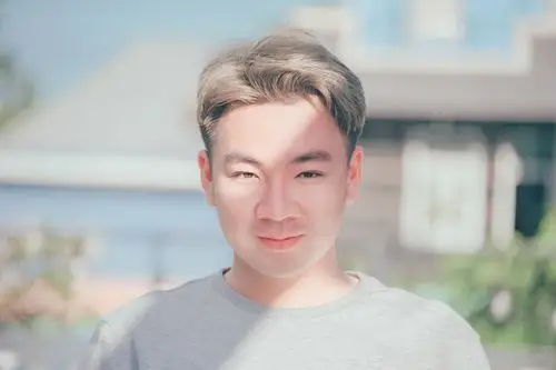 穿灰色圆领衬衣的男人在焦点照片上微笑