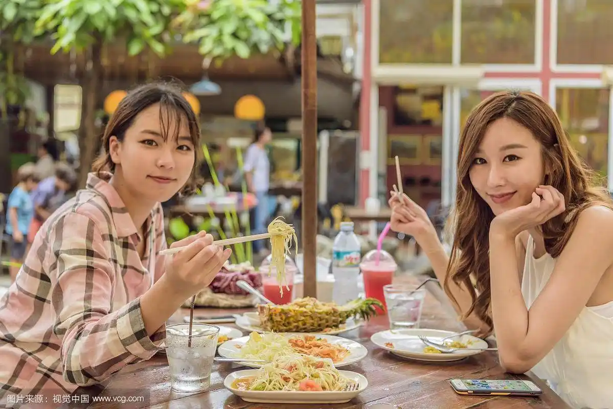 两个女人在泰国餐馆吃饭的照片