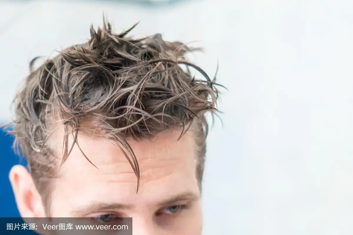 男人在家里洗完澡后,把头发弄湿,拿着毛巾