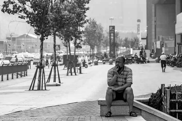 书店门口坐着一位抽烟的大叔.