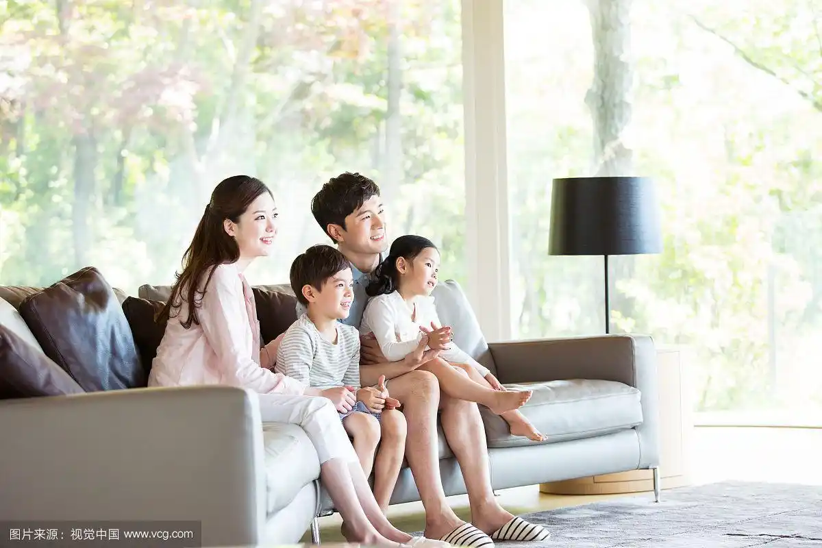 一家人坐在沙发上看电视