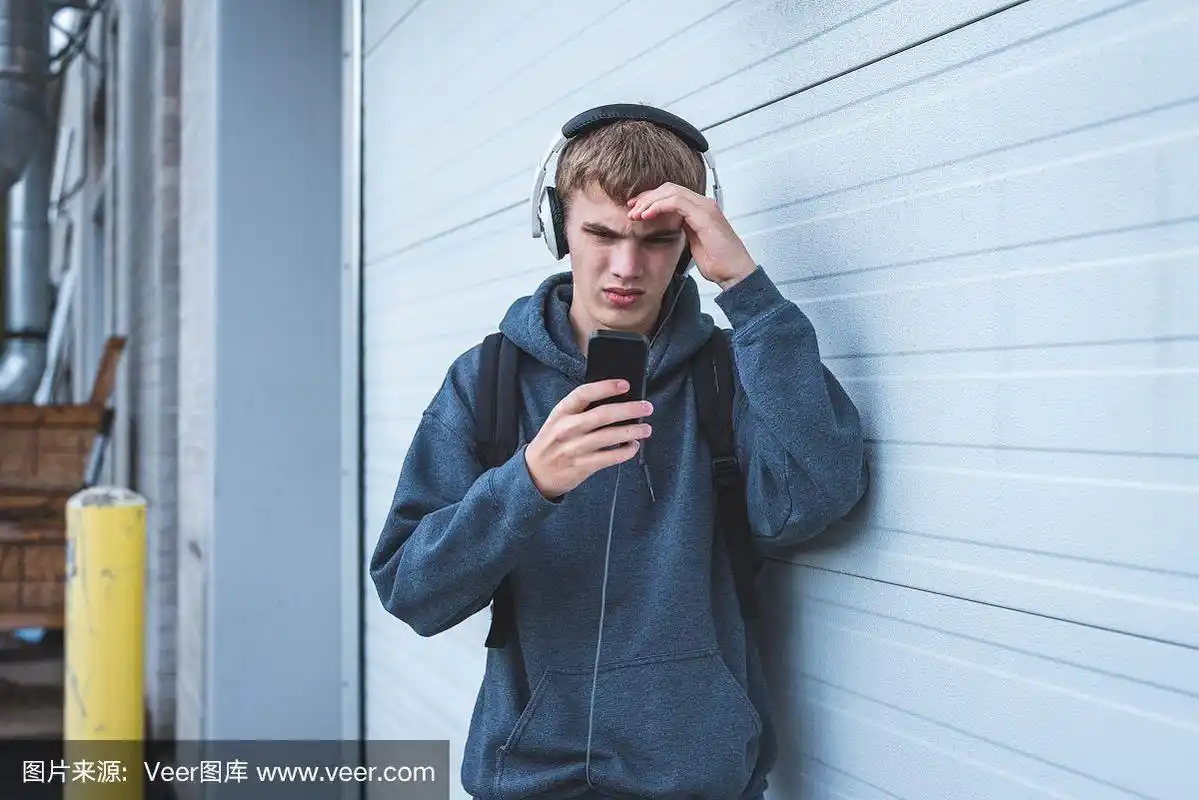 悲伤的少年戴着耳机听音乐.