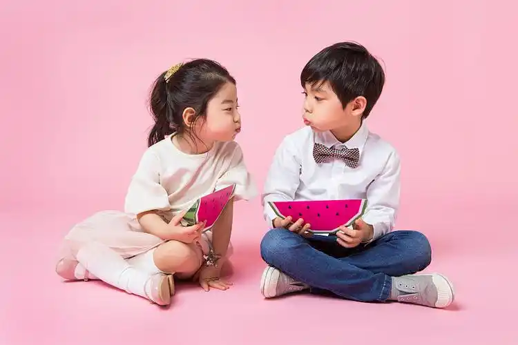 小男孩和小女孩拿着冰淇淋在粉红色的背景图片素材