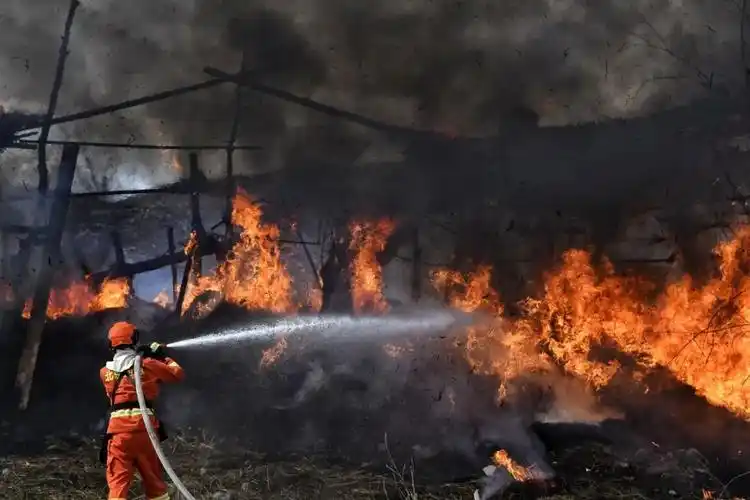 " 在常规灭火训练现场 消防员5人一组 有的手持风力灭火机将火焰吹离