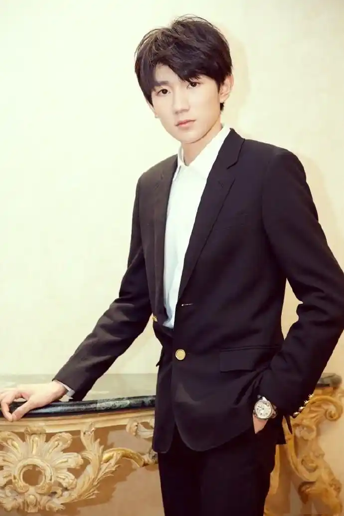 王源当天身穿黑色西装,手戴腕表搭配皮鞋,精神十足.