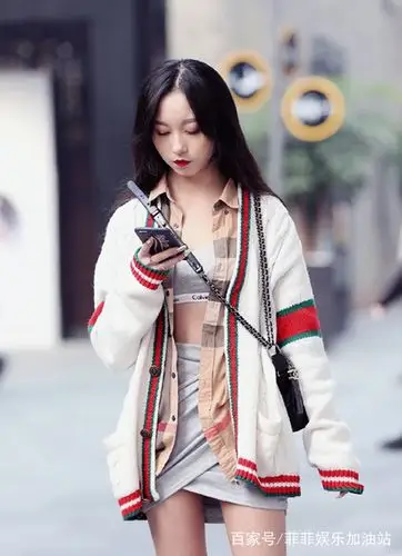 小姐姐穿着针织上衣,斜挎着黑色的笑皮包,气质的长发披散在背后.