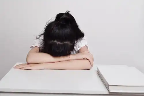 一个女学生趴在桌子上休息