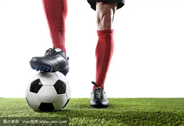 足球运动员在草地上踢球时的腿和脚