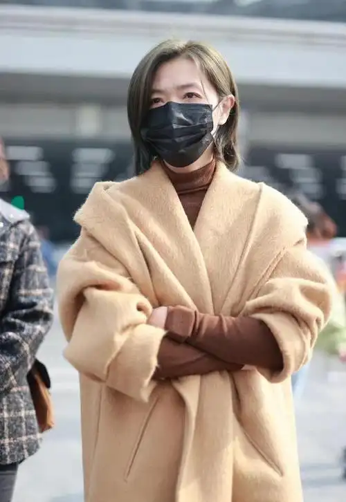 万茜机场私服街拍穿卡其色大衣配棕色毛衣和直筒裤高级时尚