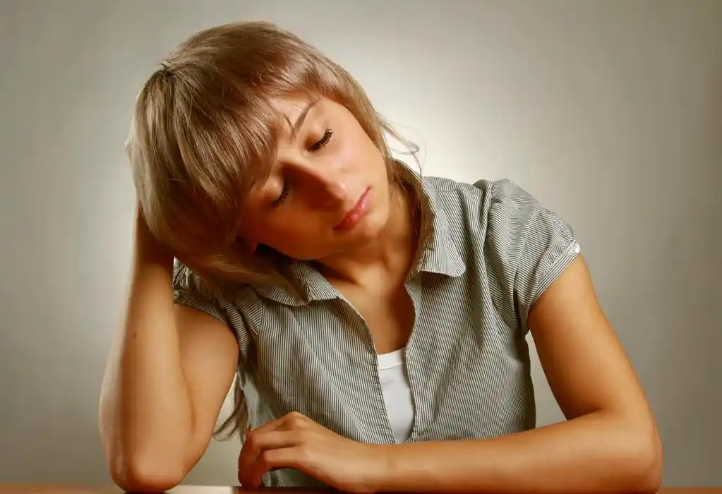 年轻的疲倦的女人,累了的少妇,孤立的灰色