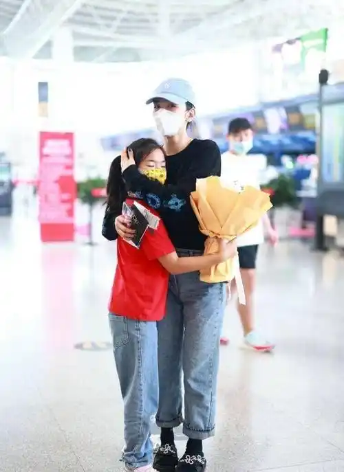 黄奕带女儿低调现身机场,踩拖鞋休闲随性,女儿戴珍珠项链太浮夸_风格