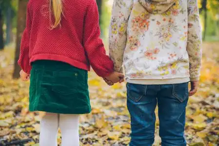 小人玩耍手牵手两个小女孩女朋友手牵手在秋城公园玩耍照片