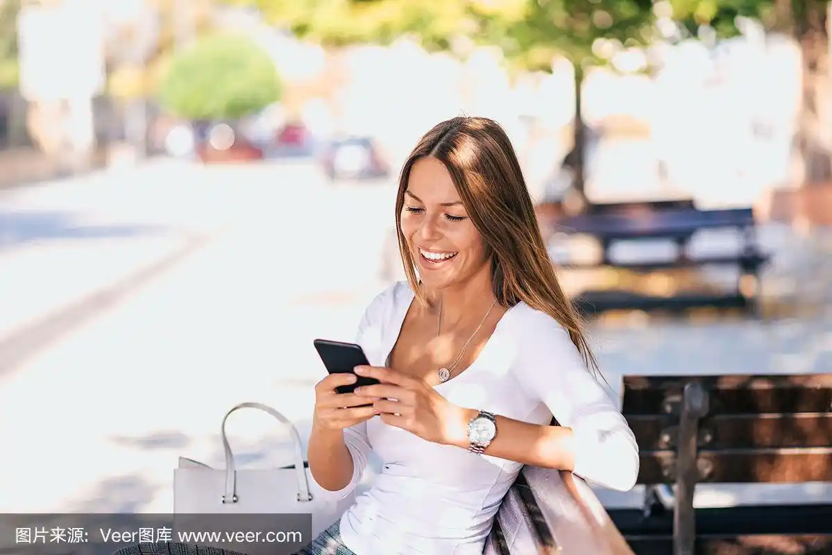 迷人的女孩在户外发短信.