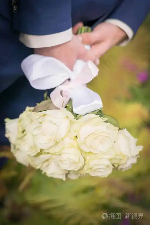 新娘手上捧着一束白玫瑰