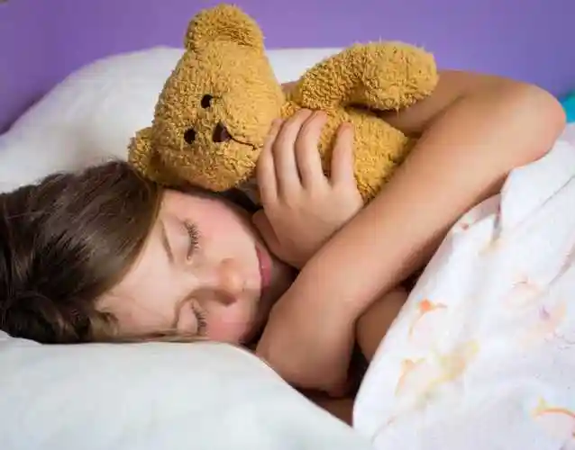 抱着泰迪熊睡觉的小女孩