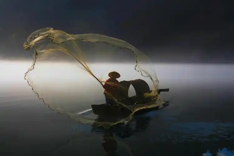 雾锁小东江,渔夫捕鱼忙.