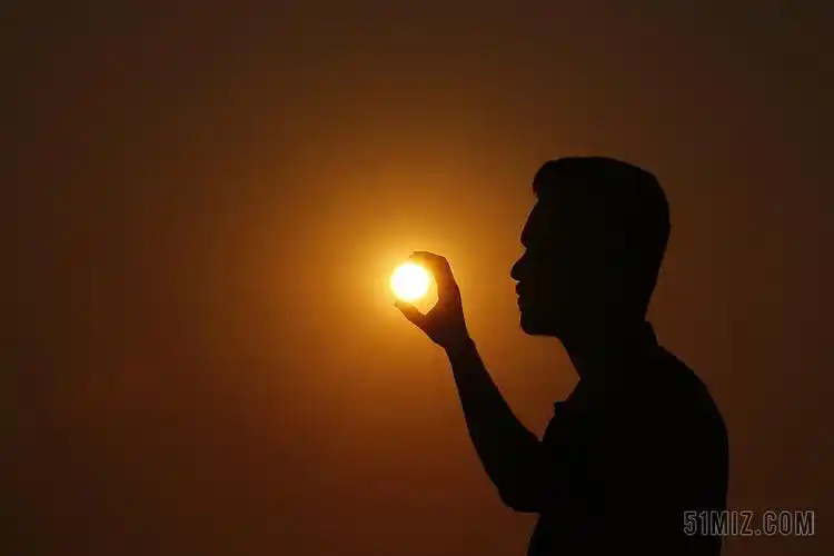 人像摄影自然取景创意侧脸影子错位借位日落日出手抓住太阳宣传图片
