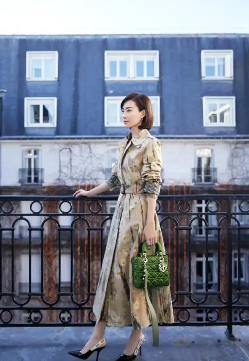 王丽坤身穿卡其色印图风衣配黑色高跟鞋,气质感十足,时尚又文艺