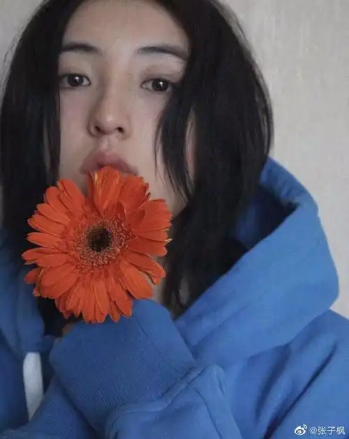 张子枫晒九宫格自拍穿蓝色卫衣持花摆pose