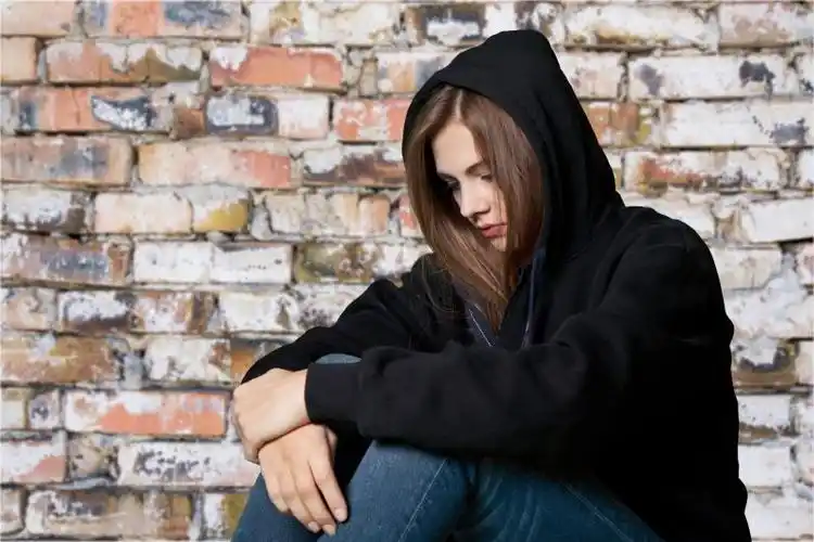 长发女孩戴着帽子低头难过