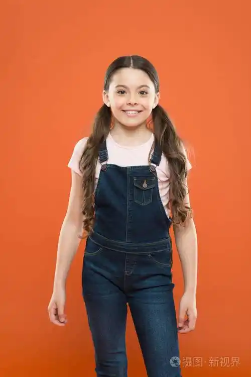 展望未来.橙色背景下的快乐孩子.小孩笑得很漂亮.