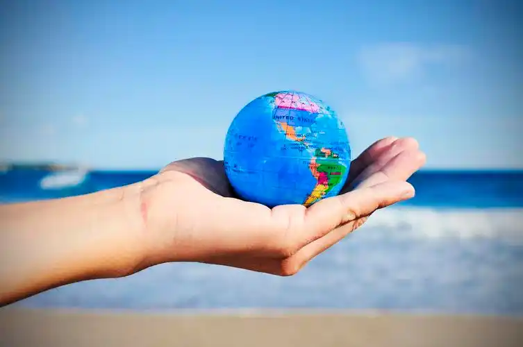 蓝色天空下一个手握着地球仪世界卫生日