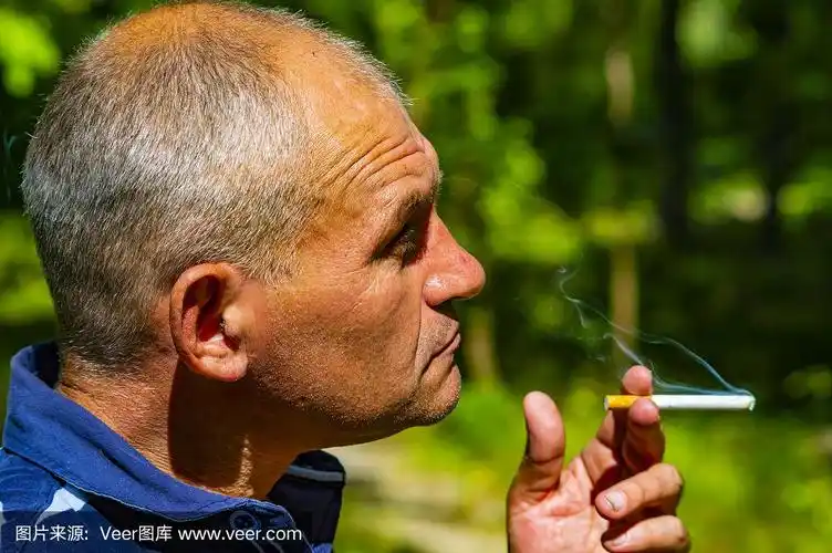 一个男人在晚上抽烟,特写.