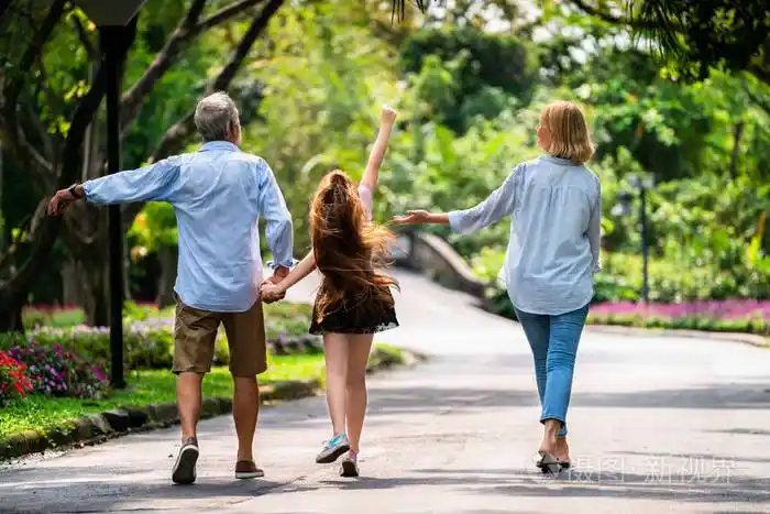 快乐健康的一家人一起在公园里散步家庭结合的概念