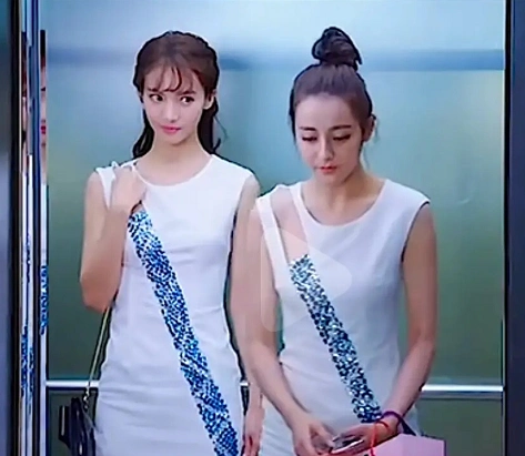 照片里面的迪丽热巴穿着一件白色的无袖短裙,短裙的肩部一边还有一块