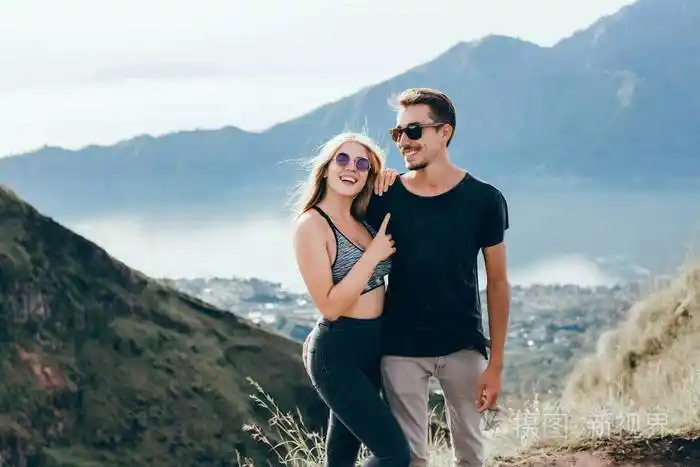 情侣旅行者男女坐在悬崖上放松的山和云鸟瞰爱情和旅行快乐的情感生活