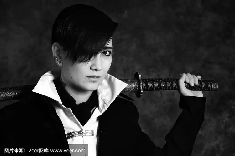 一名年轻亚洲男子肩上扛着武士刀.