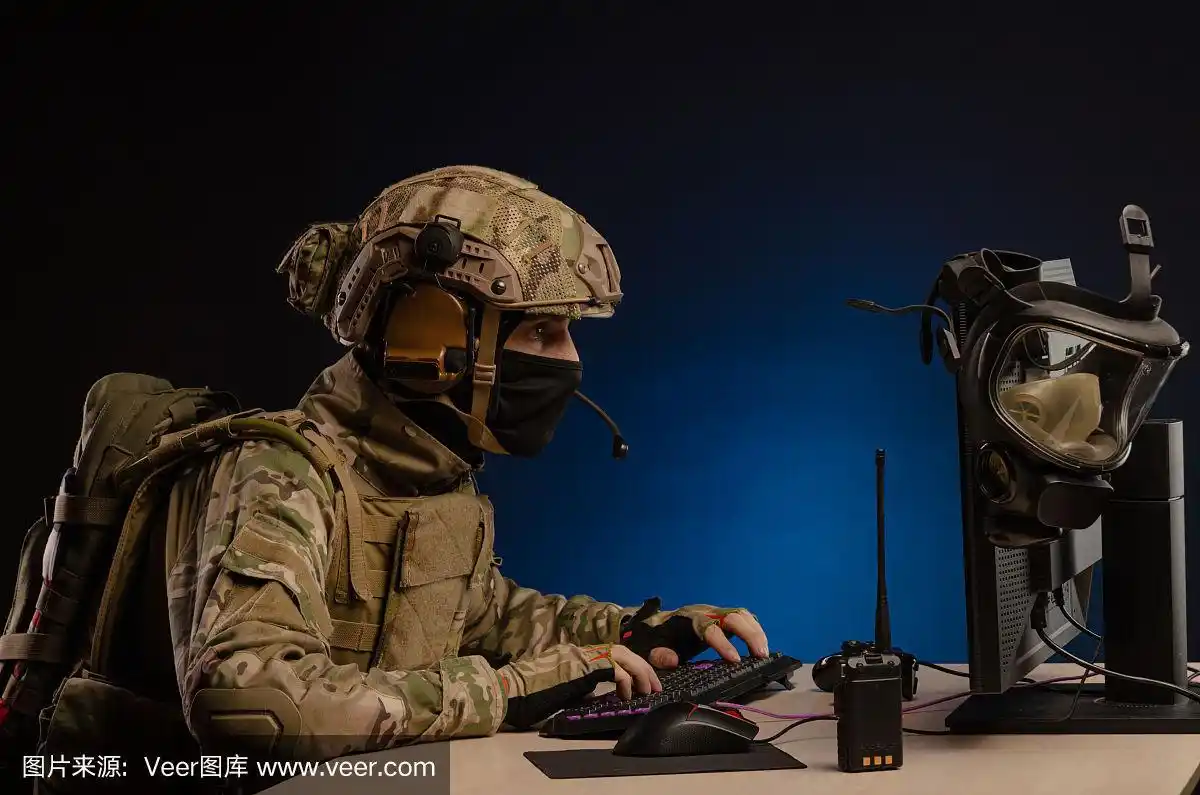 身着军装的军人坐在电脑前进行网络战