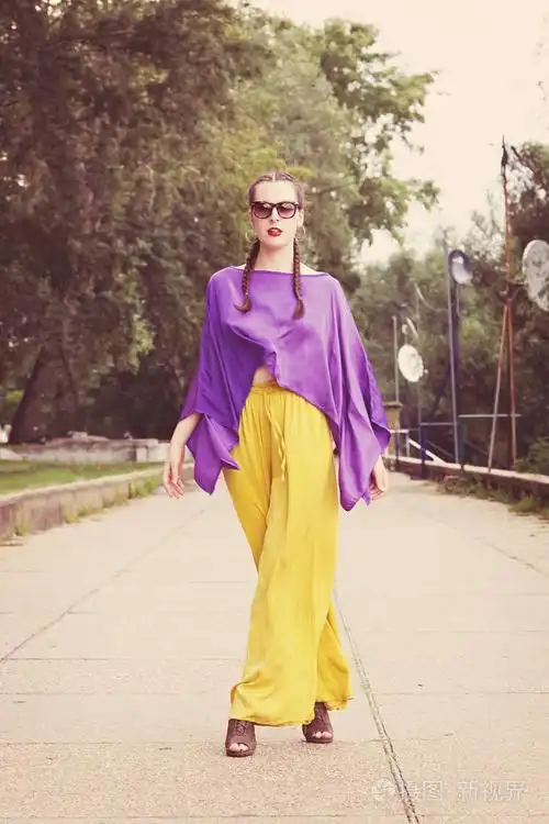 在公园散步时摆姿势拍照的漂亮年轻女子时装模特