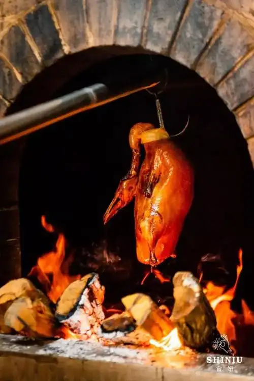 鸭肉蘸着酱料,加点小配菜,卷进饼皮里是老北京烤鸭的传统吃法